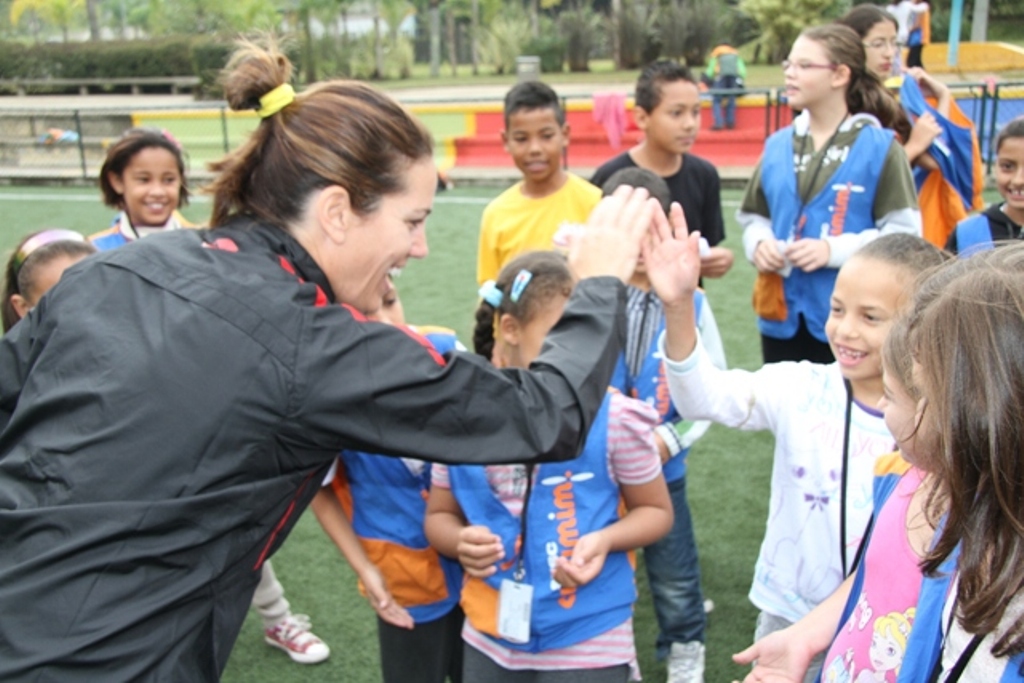 Julie Foudy handing out high fives in Brazil